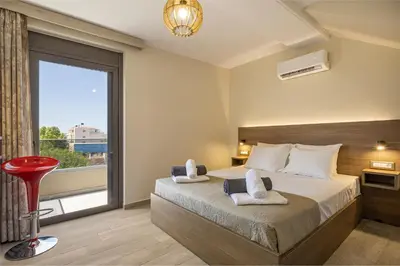 a bedroom with a bed and a large window at Chris and Stratos villa with private ecologic pool and kid's playground! in Mourniaí