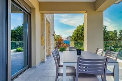 a dining room with a table and chairs on a patio at Chris and Stratos villa with private ecologic pool and kid's playground! in Mourniaí