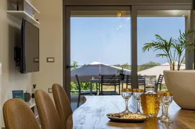 a dining room table with wine glasses on it at Chris and Stratos villa with private ecologic pool and kid's playground! in Mourniaí
