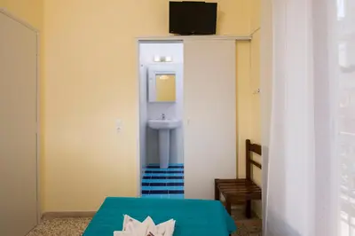 a bathroom with a sink and a bed in a room at Penelopi Rooms in Chania Town