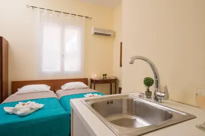 a kitchen with a sink and a bed at Penelopi Rooms in Chania Town