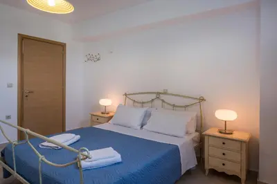a bedroom with a bed with a blue blanket and two lamps at Villa Katerina with Private Pool in Chania Town