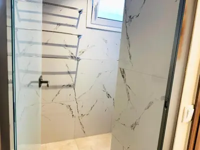 a bathroom with a shower with marble walls at Matina Room in Chania Town