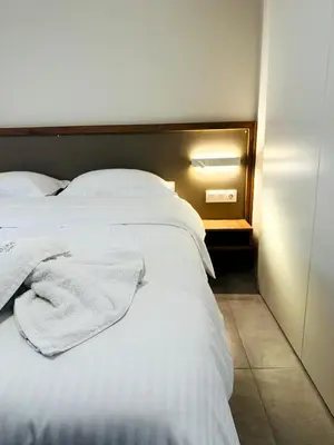 a bed with white sheets and pillows in a room at Matina Room in Chania Town