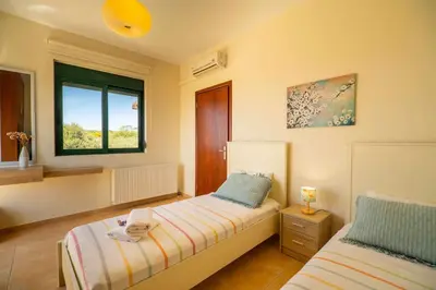 a bedroom with two beds and a window at Villa Nimertis in Xirokámbion