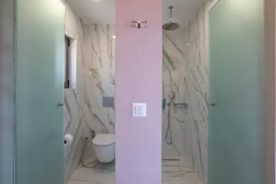 a bathroom with a toilet and a shower with marble walls at Alexandras's Mansion in Ayiá