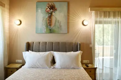 a bedroom with a bed with two pillows and a painting at Alexandras's Mansion in Ayiá