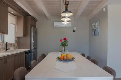 a kitchen with a table with a bowl of fruit on it at Alexandras's Mansion - Alexinia's House in Ayiá