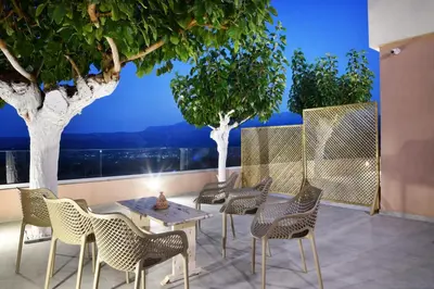 a patio with chairs and a table and trees at Alexandras's Mansion - Fragkia's House in Ayiá