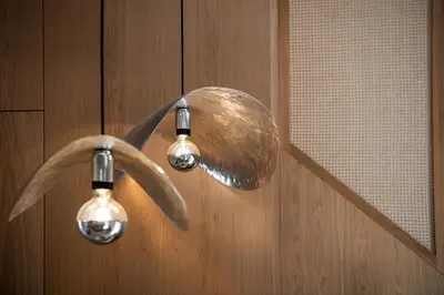 a shower head with two lights on a wooden wall at Domi Luxury Apartment by Cura Villas Collection in Chania Town