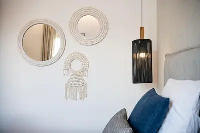 a bedroom with mirrors on the wall and a bed at Domi Luxury Apartment by Cura Villas Collection in Chania Town