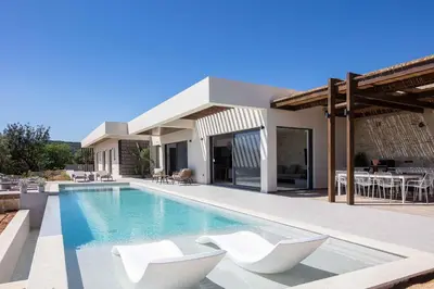 a villa with a swimming pool and two white chairs at Villa Aglaea I Saltwater Pool & Amazing Seaview! in Chania Town