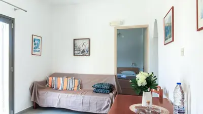 a living room with a bed and a table at Anchris Paleochora in Palaiochóra