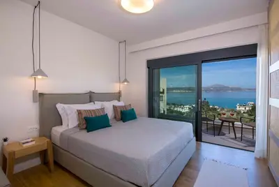 a bedroom with a large bed and a large window at Kalyves Royal Villa I 