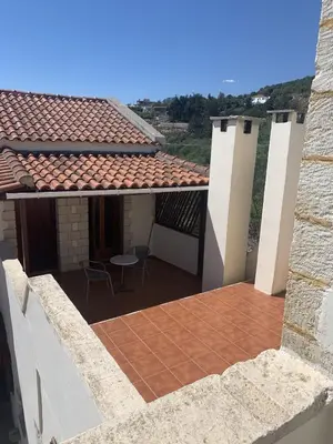 a balcony of a house with a table and a roof at Carlas House, Kalyves in Tsivarás