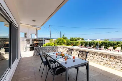 a table and chairs on the patio of a house at Villa Athena by Villa Plus in Almirida