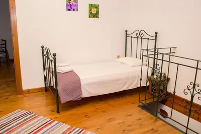 a bedroom with a metal bed with white sheets at Traditional house in Fres in Karés