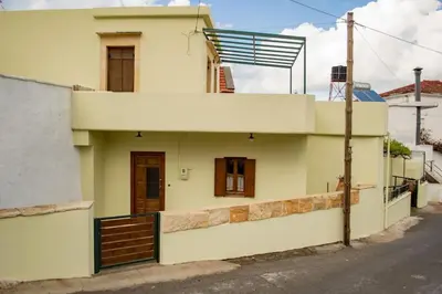 a white house with a gate and a street at Traditional house in Fres in Karés