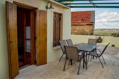 a patio with a table and chairs on a balcony at Traditional house in Fres in Karés