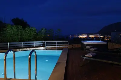 a swimming pool on the roof of a building at night at Thearia villa I - seaview , private heated pool & jacuzzi in Souda