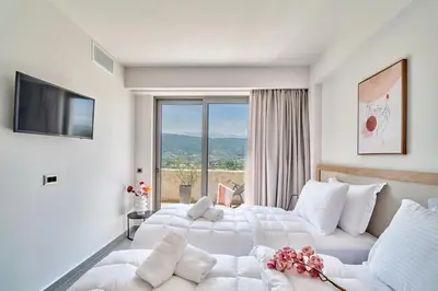 a hotel room with two beds and a large window at Thearia villa I - seaview , private heated pool & jacuzzi in Souda