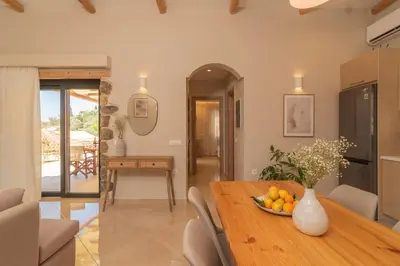 a kitchen and dining room with a table with a bowl of fruit at Aoria Villas in Palaiochóra