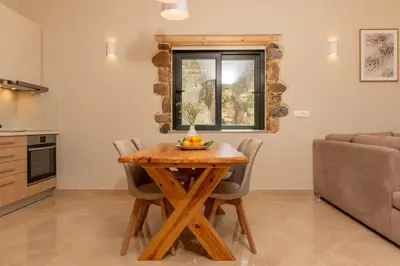 a kitchen and dining room with a wooden table and chairs at Aoria Villas in Palaiochóra