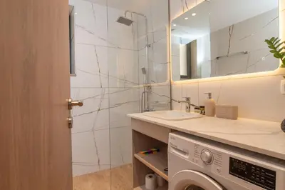 a bathroom with a washing machine and a sink at Aoria Villas in Palaiochóra