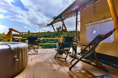 a couple of chairs sitting on a deck with a view at Civara Chalet - Private Glamping in nature with Jacuzzi in Tsivarás