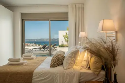 a bedroom with a bed with a view of the ocean at AmphiMatrion Luxury Residence in Kalyves