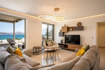 a living room with a couch and a tv at AmphiMatrion Luxury Residence in Kalyves
