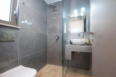a bathroom with a shower with a sink and a toilet at Villa Idyllic in Maleme