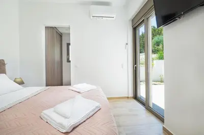 a bedroom with a large bed with white sheets at Villa Idyllic in Maleme