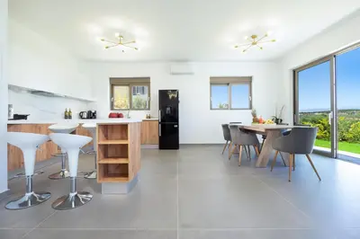 a kitchen with a counter and a table and chairs at Villa Idyllic in Maleme