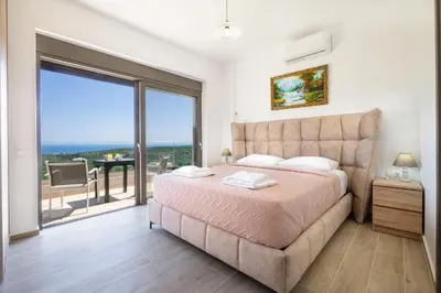 a bedroom with a large bed and a balcony at Etheria Villa in Chania Town