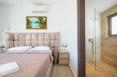 a bedroom with a king sized bed and a shower at Etheria Villa in Chania Town