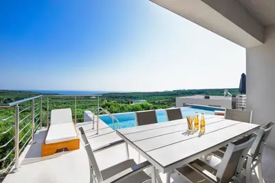 a dining table on the balcony of a house at Etheria Villa in Chania Town