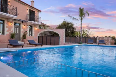 a swimming pool in front of a house at Villa Kois by PosarelliVillas in Tzitzifés