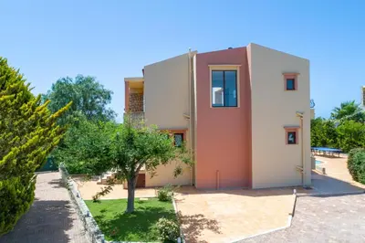 a house in a garden with a tree at Pasiphae villas 1 & 2 in Stalos