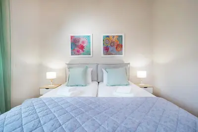 a bedroom with a blue bed with two lamps at Villa Avo in Chania Town