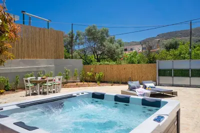 a pool in a backyard with a table and chairs at Villa Avo in Chania Town
