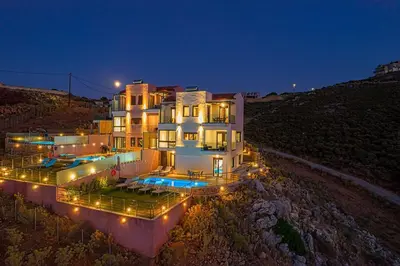 a large house with lights in front of it at night at Apartment Lia with private eco pool - Amazing view in Chania Town