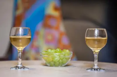 two glasses of white wine and a bowl of green grapes at IFIGENIA TRAD.ROOMS IN OLDTOWN BY.MARIOS in Chania Town