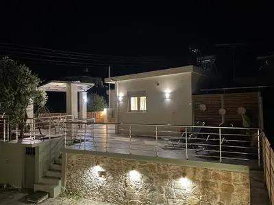 a house with a balcony at night with lights at Aryiro's Residence,Cozy&Sunny in Alikianós