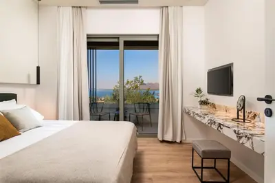 a bedroom with a bed and a view of the ocean at 2 sea view Villas as 1 by Chania Living Stories in Chania Town