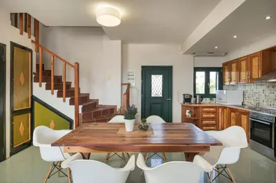 a kitchen and dining room with a wooden table and white chairs at Seafront Villa Shore, Sea & Sun Villas in Chorafakia