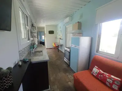 a kitchen with a refrigerator and a red couch in a room at Micro_Ble vacation home in Ropanianá