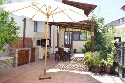 a patio with an umbrella and a table at Villa Helidoni in Pondikianá