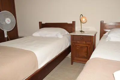 a bedroom with two twin beds and a fan at Villa Helidoni in Pondikianá