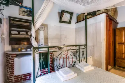 a bedroom with a bed with a wrought iron headboard at IFIGENIA ROOMS BY MARIOS in Chania Town